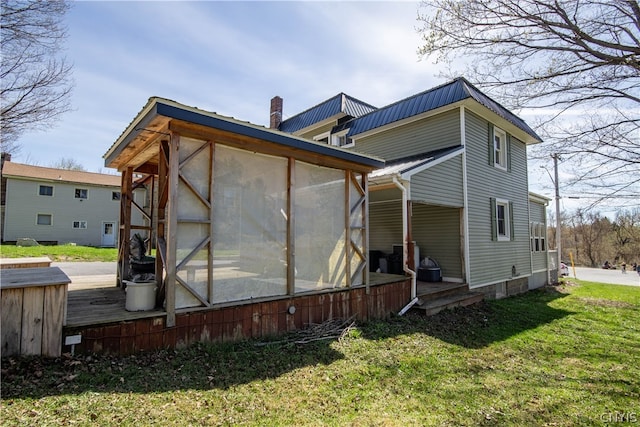 exterior space featuring a yard and a sunroom