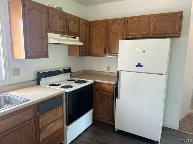 kitchen with dark hardwood / wood-style flooring, white appliances, and sink