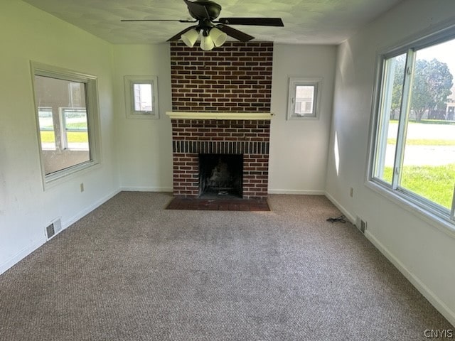 unfurnished living room with carpet flooring, ceiling fan, and a brick fireplace