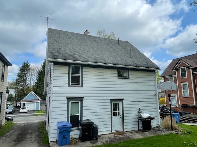 back of house with a garage and an outdoor structure