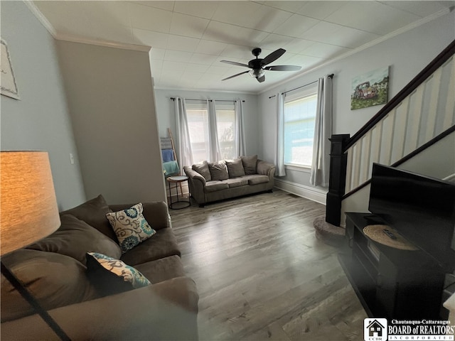 living room with ornamental molding, wood-type flooring, and ceiling fan