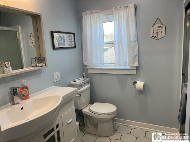 bathroom featuring vanity with extensive cabinet space, toilet, and tile flooring