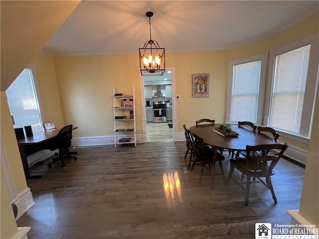 dining room with dark hardwood / wood-style floors, a notable chandelier, and crown molding