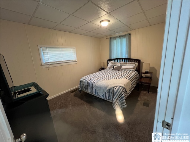 carpeted bedroom featuring a drop ceiling