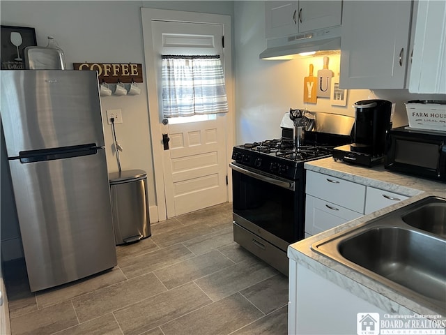 kitchen featuring white cabinetry, range with gas cooktop, and stainless steel fridge