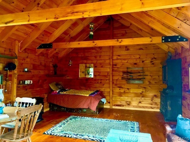 bedroom featuring wooden walls, hardwood / wood-style floors, wooden ceiling, and vaulted ceiling with beams