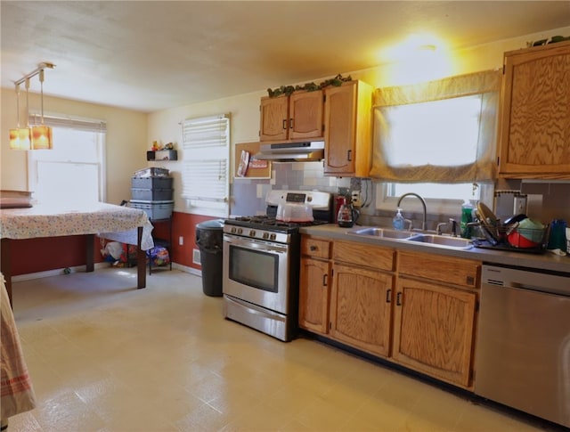 kitchen with stainless steel appliances, pendant lighting, sink, tasteful backsplash, and light tile floors