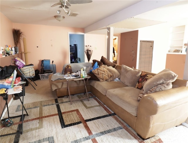 living room with built in shelves, carpet, and ceiling fan