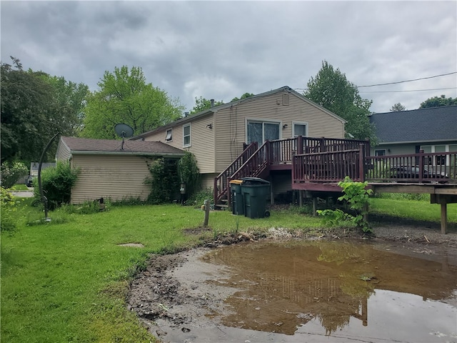 rear view of house featuring a yard and a deck