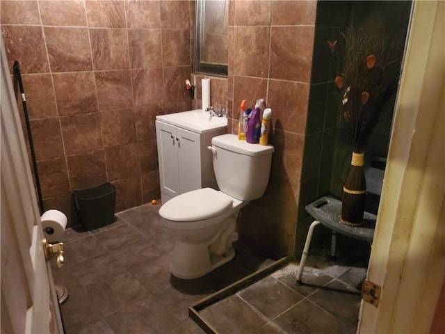 bathroom featuring tile walls, tile flooring, vanity, and toilet