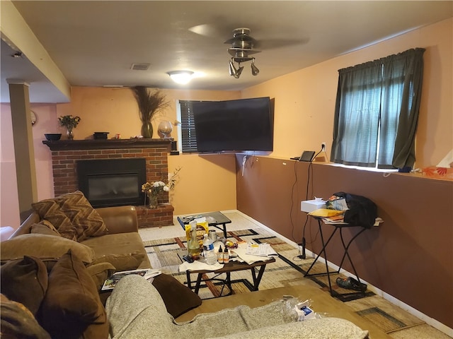 living room featuring a brick fireplace and ceiling fan