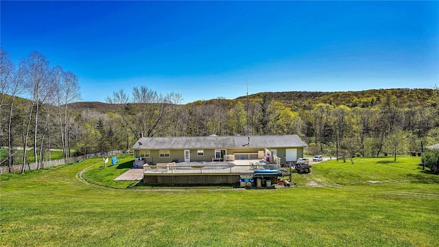 rear view of house with a lawn and a wooden deck