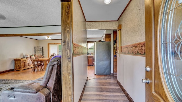 corridor with wood-type flooring and a textured ceiling