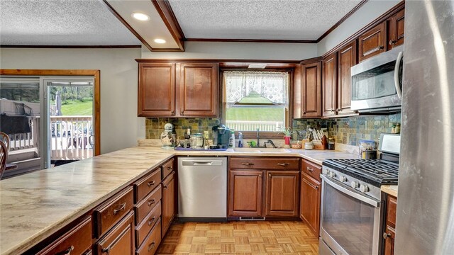 kitchen featuring backsplash, appliances with stainless steel finishes, plenty of natural light, and light parquet floors