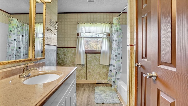 bathroom featuring shower / tub combo with curtain, ornamental molding, a textured ceiling, and large vanity