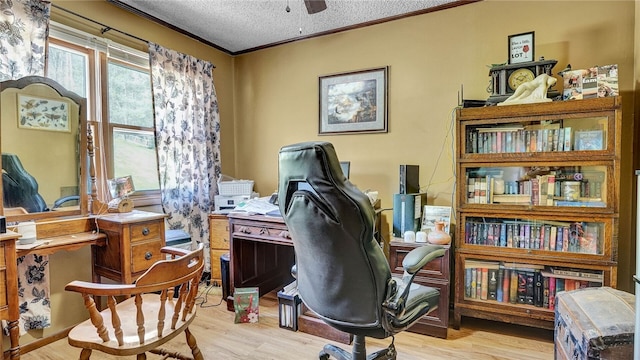 office with ceiling fan, ornamental molding, a textured ceiling, and light wood-type flooring