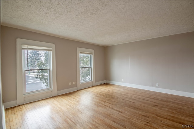 unfurnished room featuring a textured ceiling and light hardwood / wood-style floors