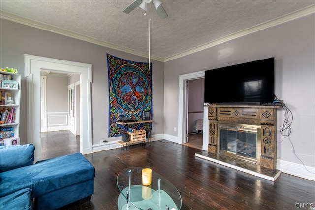 living room featuring wood-type flooring, a textured ceiling, ceiling fan, and ornamental molding