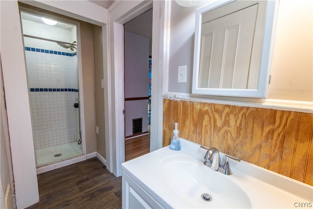 bathroom with sink, ceiling fan, an enclosed shower, and hardwood / wood-style flooring