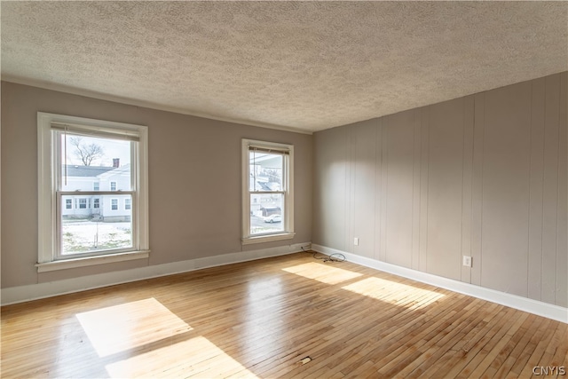 unfurnished room featuring light hardwood / wood-style floors and a textured ceiling