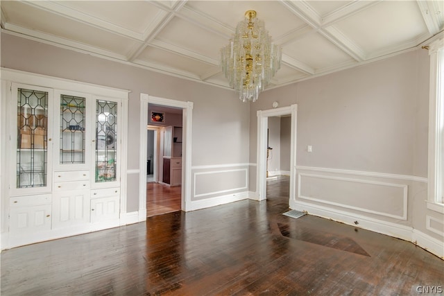 spare room featuring dark hardwood / wood-style flooring, beam ceiling, a chandelier, and coffered ceiling