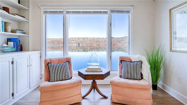 living area featuring a water view and light hardwood / wood-style floors