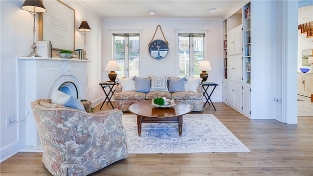 sitting room with light hardwood / wood-style floors and crown molding