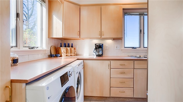 clothes washing area featuring a wealth of natural light and washer and dryer