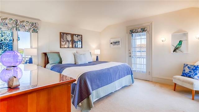 bedroom with light colored carpet and lofted ceiling