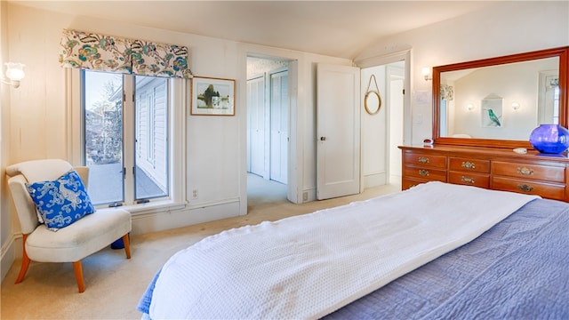 carpeted bedroom with a closet and lofted ceiling