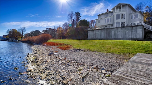 exterior space featuring a lawn and a water view