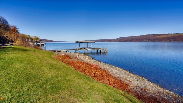 view of dock featuring a water view and a yard