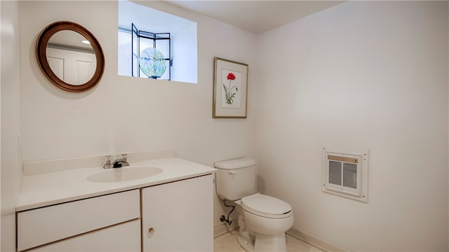 bathroom with tile patterned flooring, vanity, heating unit, and toilet