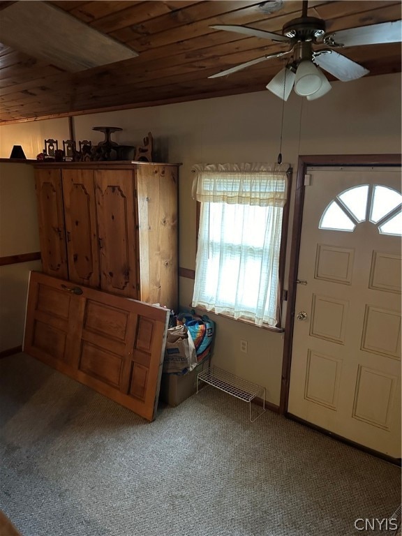 carpeted entryway featuring wood ceiling, plenty of natural light, ceiling fan, and vaulted ceiling