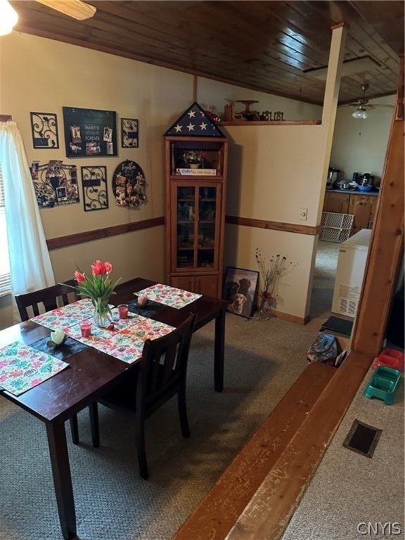 carpeted dining space featuring lofted ceiling, ceiling fan, and wood ceiling