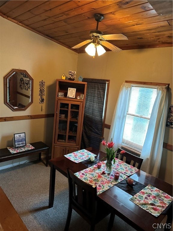 carpeted dining room featuring ceiling fan and wooden ceiling