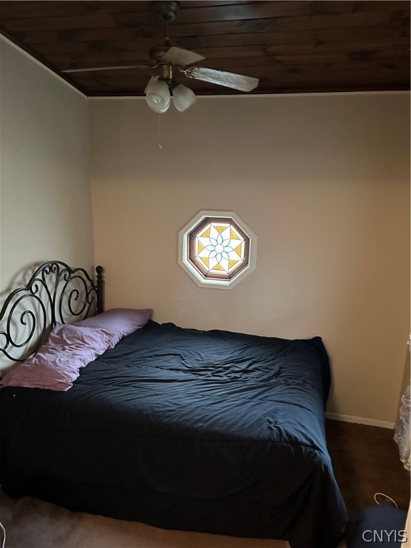 bedroom featuring wood ceiling, dark colored carpet, and ceiling fan