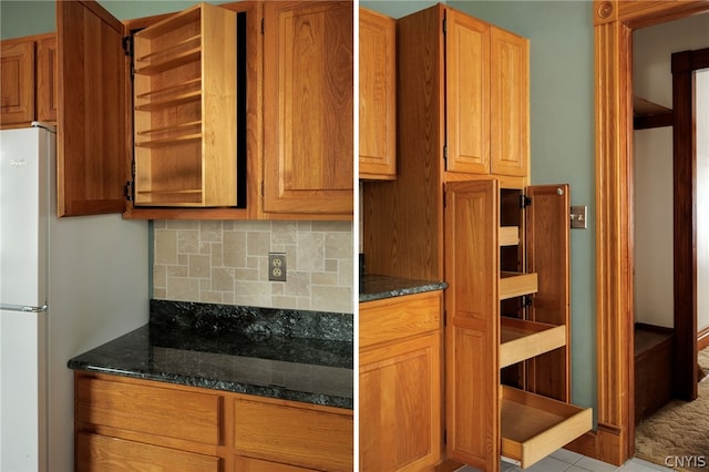 kitchen featuring dark stone countertops, decorative backsplash, and white refrigerator