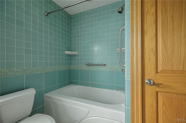 bathroom featuring tile walls, tiled shower / bath combo, and toilet