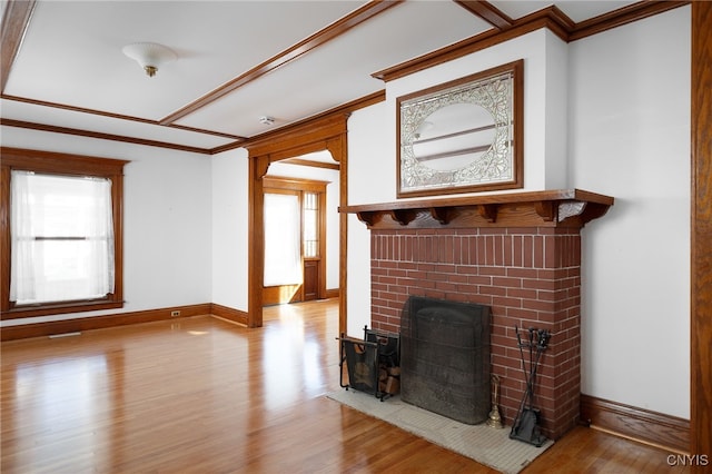 living room with a healthy amount of sunlight, light hardwood / wood-style flooring, and a brick fireplace