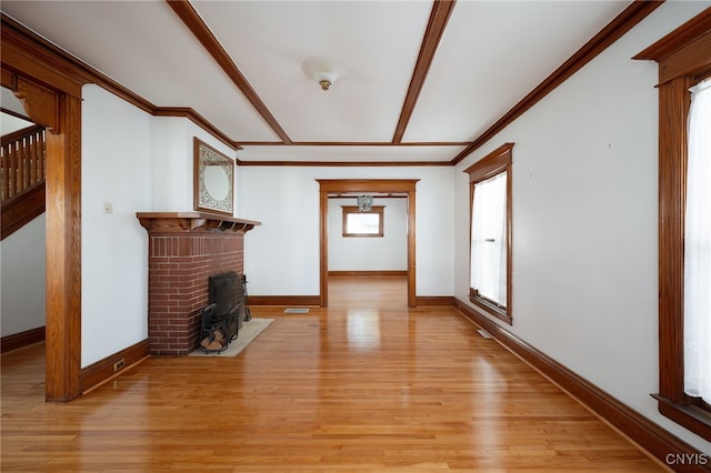 unfurnished living room with light hardwood / wood-style flooring, ornamental molding, and a fireplace