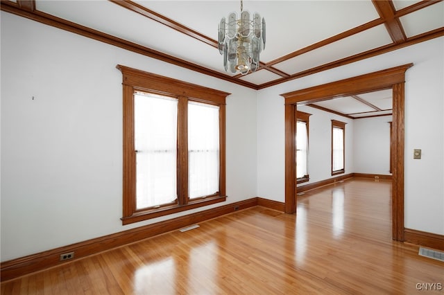 unfurnished room featuring light hardwood / wood-style floors, a notable chandelier, and ornamental molding