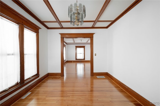 corridor with light hardwood / wood-style flooring, an inviting chandelier, and crown molding