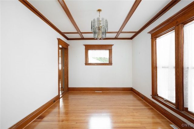 spare room featuring a notable chandelier and light wood-type flooring