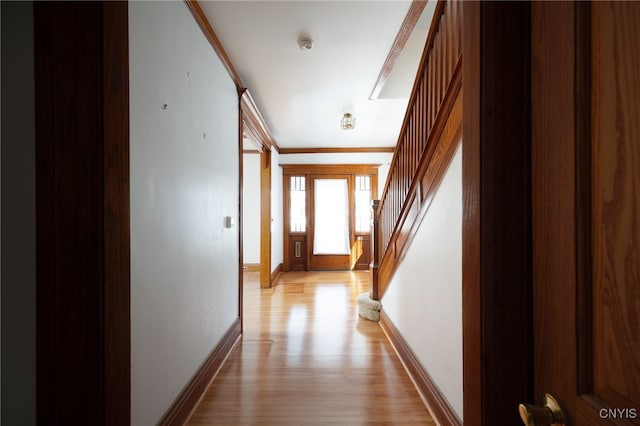 hallway featuring ornamental molding and light hardwood / wood-style floors