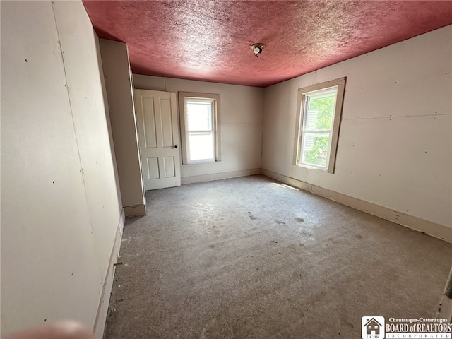 unfurnished room with concrete flooring and a textured ceiling