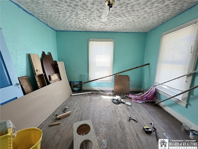 misc room with a wealth of natural light, a textured ceiling, and hardwood / wood-style floors