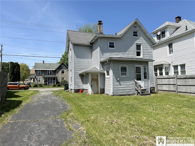 back of house with a lawn