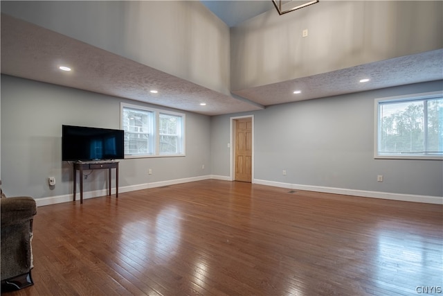 unfurnished living room with dark hardwood / wood-style floors and a textured ceiling