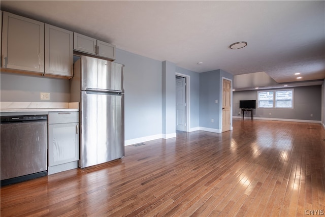 kitchen with gray cabinetry, stainless steel appliances, and wood-type flooring